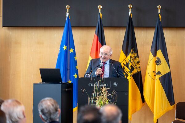 Peter Hofelich richtet sich an die Zuhörer mit einem Mikrofon in der Hand