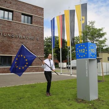 Axel Müller hisst die Europaflagge vor der Notruf Stele in Stuttgart